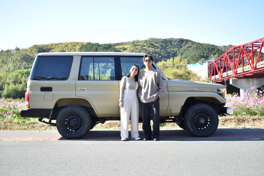 トヨタ・ランドクルーザー70の前で笑顔を見せる村上さん夫婦