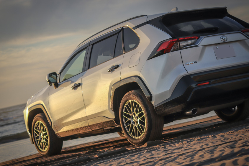 海岸で夕陽を浴びるトヨタ・RAV4
