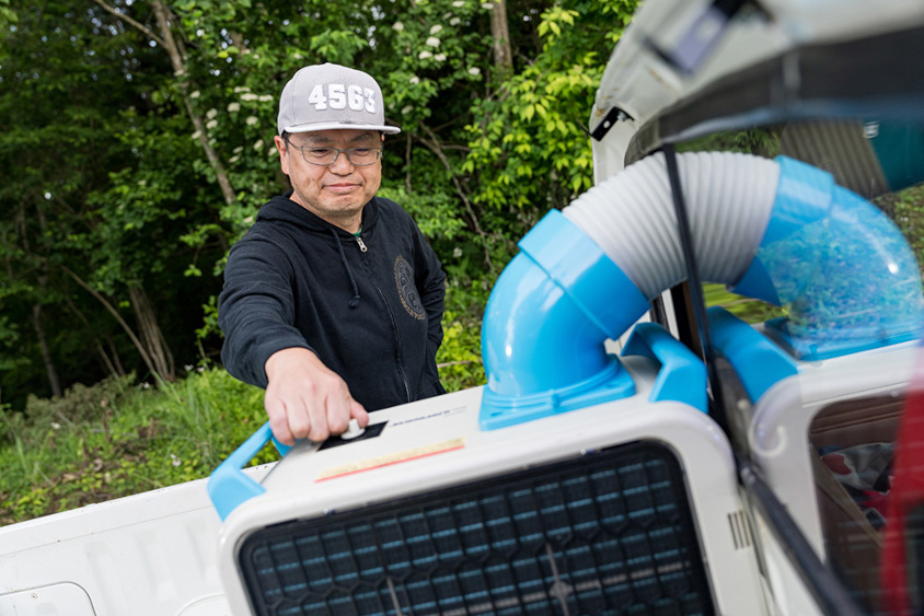 日産・サニートラックの荷台のスポットクーラーとオーナーの新田番地さん