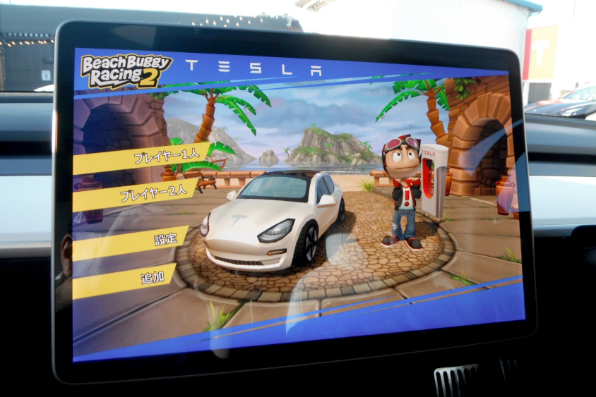 大型モニターで遊べるゲームは、実際にテスラのステアリングやアクセル/ブレーキペダルを使ってプレイ
