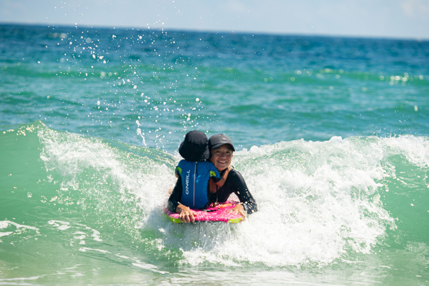 ボディボードをするお母さんとお子さん