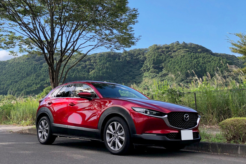 マツダ・CX-30と木の生い茂る山