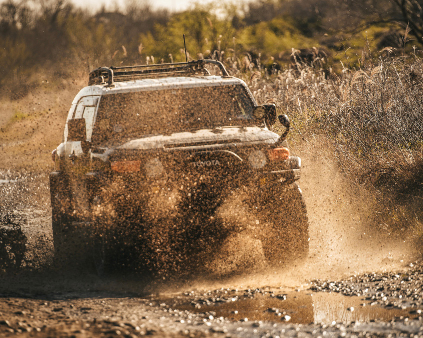 オフロードで泥をはね上げるトヨタ・FJクルーザー