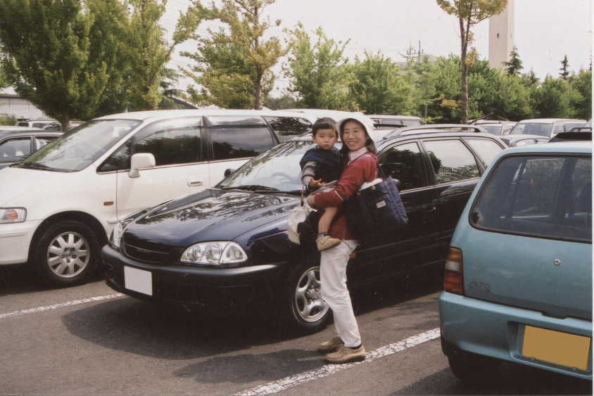 お父さんのカルディナの前で笑顔を見せるお母さんとオーナーさん