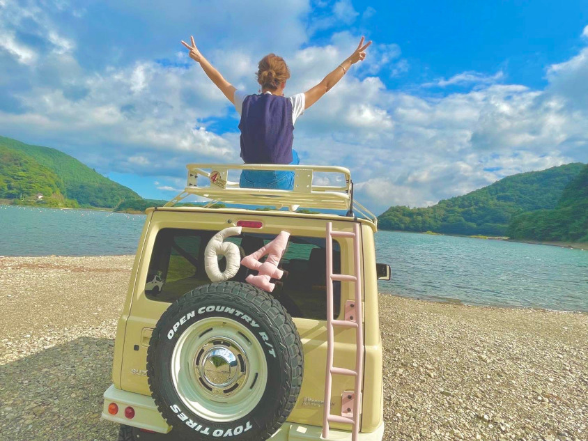 スズキ・ジムニー（JB64）のルーフの上でポーズをとるオーナーさん