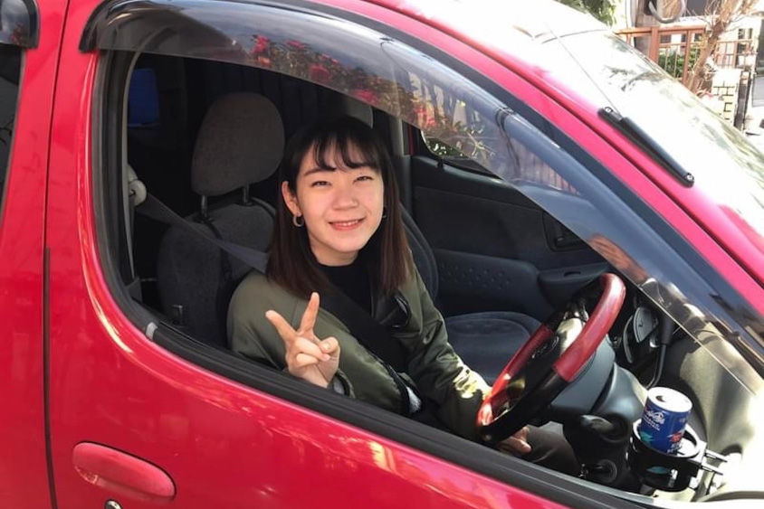トヨタ・ファンカーゴの運転席で笑顔を見せるオーナーの娘さん