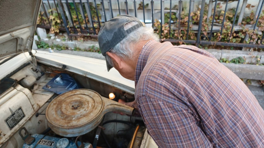 日産・ブルーバード（初代）のエンジンルームを覗くオーナーのお父様