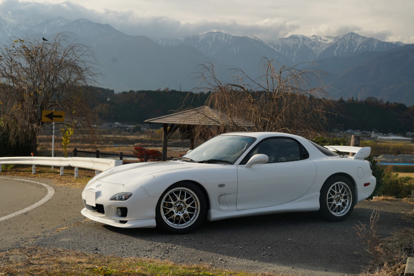 マツダ・RX-7 タイプRバサーストと山々の風景