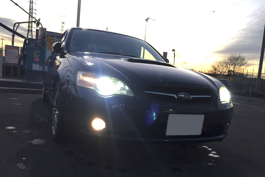 夕暮れにヘッドライトが光るスバル・レガシィB4