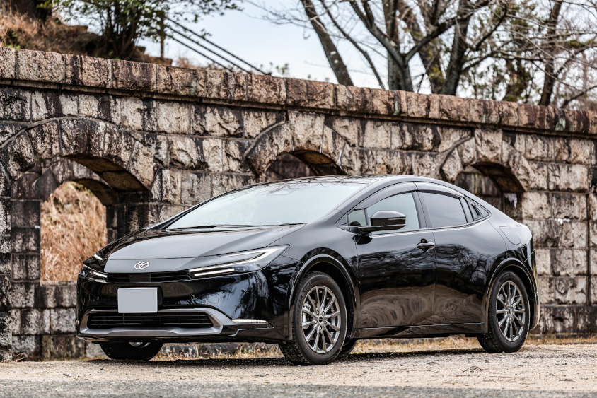 トヨタ・プリウスと雰囲気のある石の壁