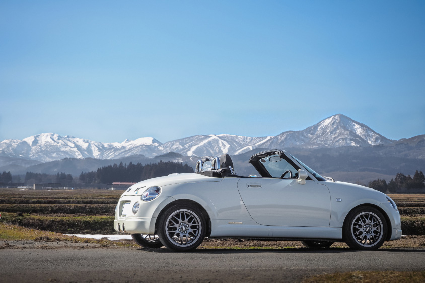ダイハツ・コペンと雪を冠する山並み