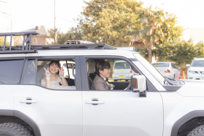 トヨタ・ランドクルーザー250の運転席に座るオーナーさんと後席から笑顔を見せる奥様