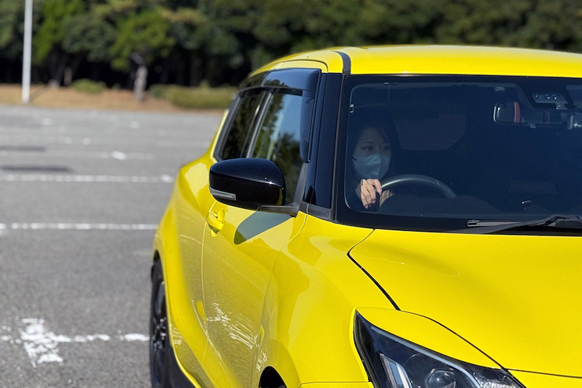 運転中のドライバーとスズキスイフトスポーツ
