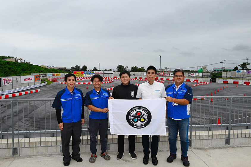 左より角田祐二氏、仲村優佑氏（レーサー、ちゃんプル沖縄大使）、赤嶺勝磨主任主事、玉城佑主査、翁長達也事務局長