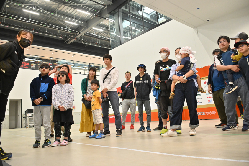 ROOKIE Racing キッズガレージツアーで説明を聞く参加者のみなさん
