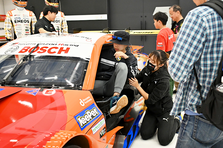 SUPER GTのマシンに乗り込むROOKIE Racingキッズガレージツアー参加者