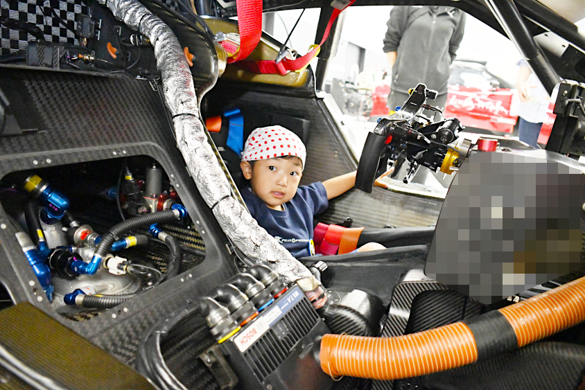 SUPER GTのマシンに座るROOKIE Racingキッズガレージツアー参加者