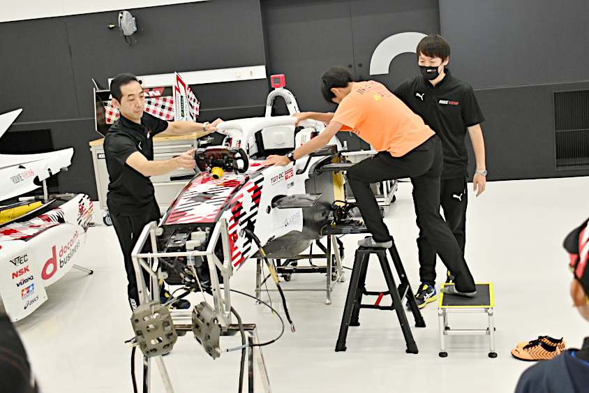 スーパーフォーミュラマシンに乗り込むROOKIE Racingキッズガレージツアーの参加者