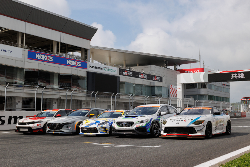 「共挑」を掲げ、スーパー耐久のST-Qクラスに参戦するホンダ、マツダ、トヨタ、スバル、日産の開発車両の富士スピードウェイのホームストレートでの記念撮影