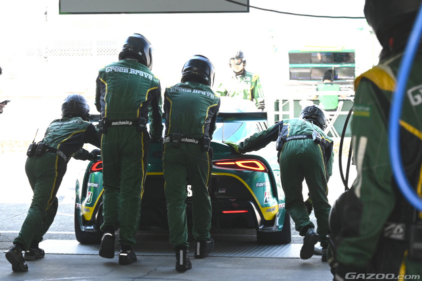 ピットの中からマシンを手押しするメカニック