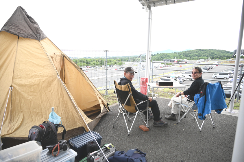 イベント広場の端のエリアで観戦する男性