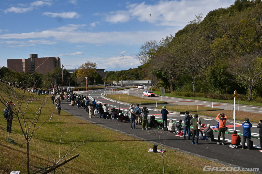 多目的広場から出て、制限速度50km/hの園内の道を高速で駆け抜けていきます（ラリージャパン2023）