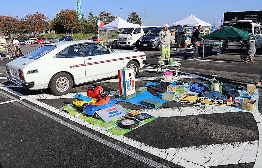 フリーマーケットの中で子どもの遊具や看板などを並べるお店。隣にいるクルマは……