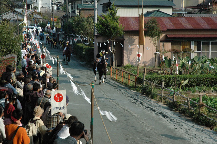 流鏑馬は「馬場駆け」から始まる。法被姿の騎者が馬に乗り、2頭で馬場を一往復。