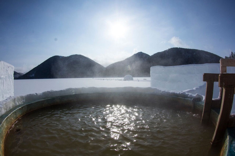 湖上に浮かぶ氷上露天風呂はまさに絶景の湯。気軽に入れる足湯もある。