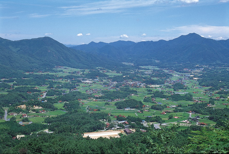島根県石見地方で生産される石州瓦の赤い屋根や緑の山々が盆地の風景を彩る。