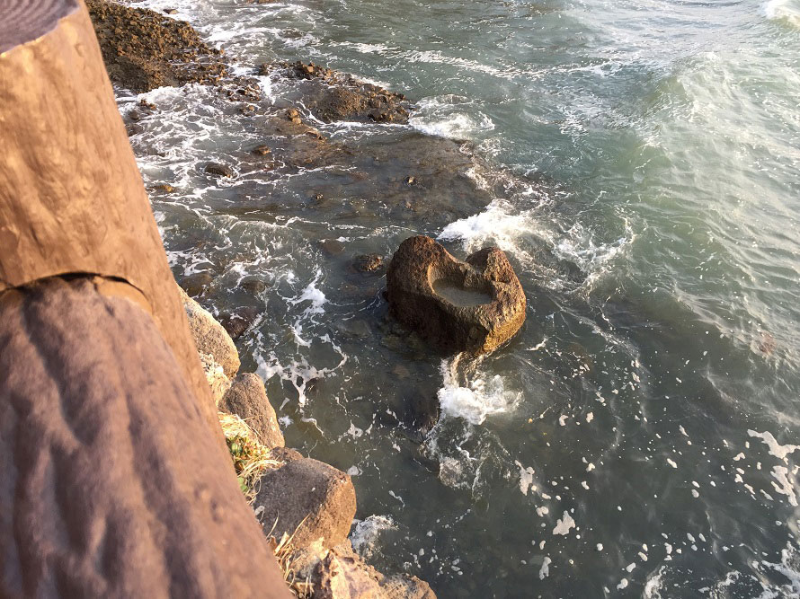 海中にあるハート型の「叶え岩」。この岩のくぼみに目がけて「願い石」を投げ入れて願掛けする。岩が現れるのは干潮時のみなのでご注意を